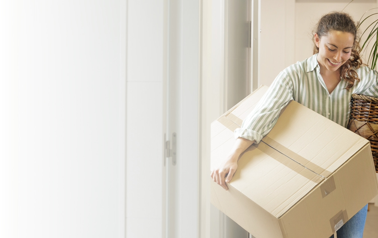 Woman moving boxes into newly rented house