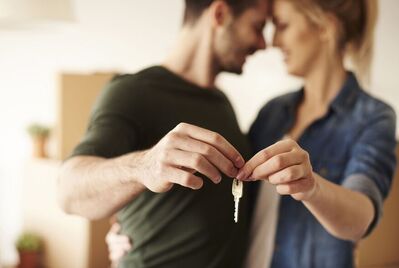 Two people holding a key