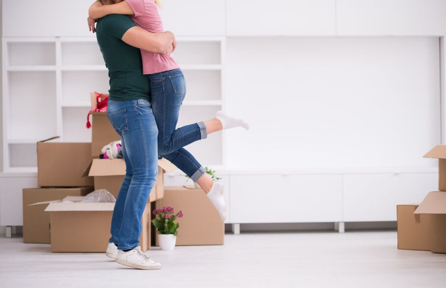 Two people hugging with boxes behind them