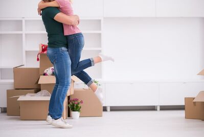 Two people hugging with boxes behind them