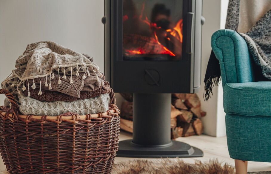 A blanket basket and an armchair in front of a fire