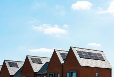 A row of houses with solar panels on the rooves