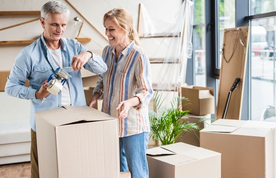 A couple packing up a cardboard box