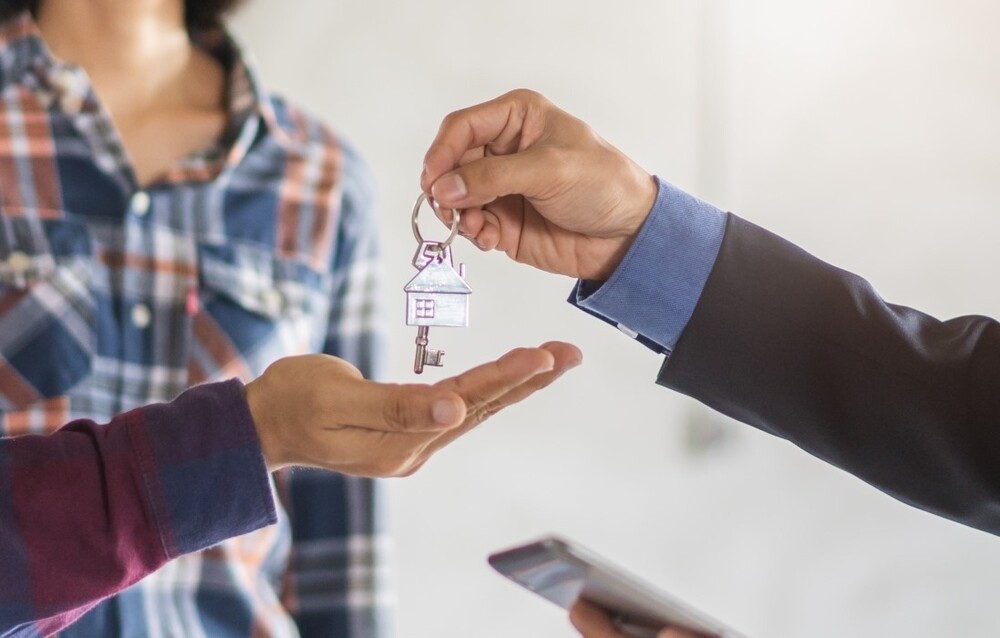 A person handing over a set of house keys