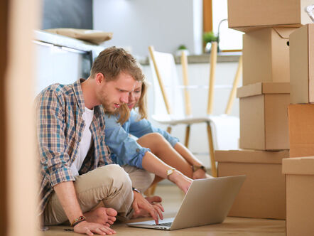 Young couple moving in new home.Sitting on floor and relaxing after unpacking.