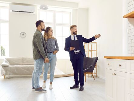 An estate agent showing a couple around a home