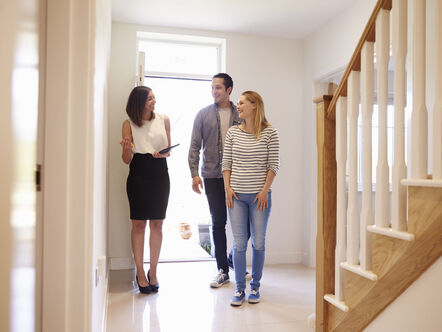 An estate agent showing a couple around a house