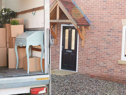 A moving van full of boxes in front of a house