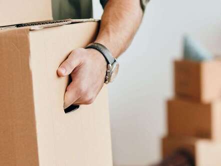 A person carrying a cardboard box