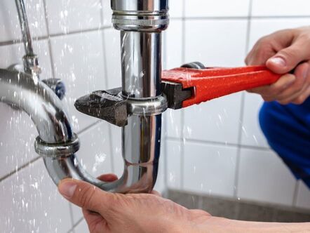 A man with a wrench fixing a leak