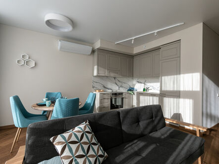 Interior of a living room in a small modern apartment furnished with grey sofa